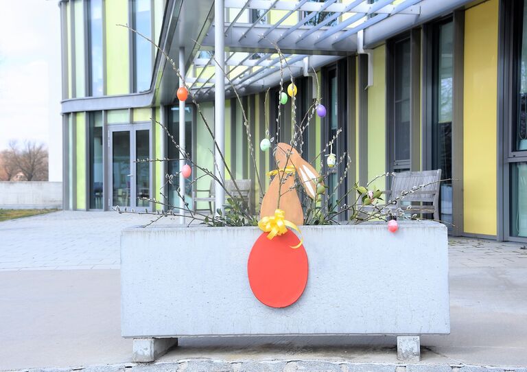 Osterdekor vor dem Eingang: Osterhase und Osterei.