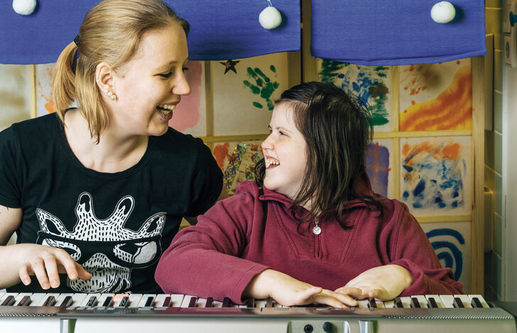 Ein Kind aus der HABIT Kids WG lächelt eine Betreuerin an.