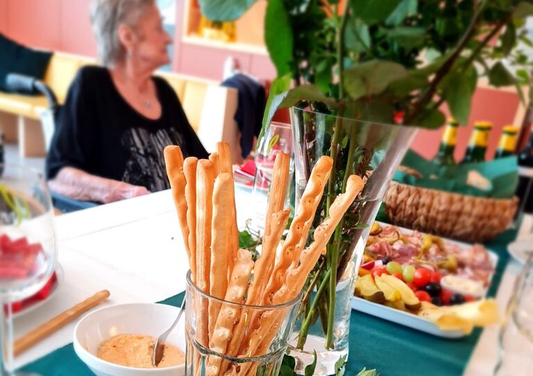 Tisch-Deko, im Hintergrund eine Bewohnerin.