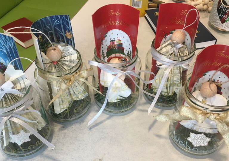 Zu sehen sind einige Gläser, die weihnachtlich dekoriert und mit einer Weihnachtsbotschaft verziert sind. Es sind Geschenke für Angehörige.