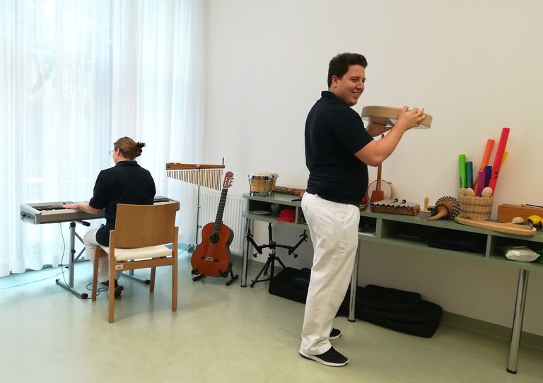 MitarbeiterInnen beim Ausprobieren von Musikinstrumenten.