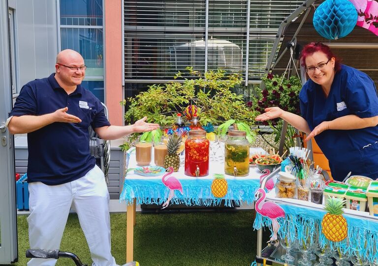 Mitarbeiter*innen präsentieren die Cocktails.