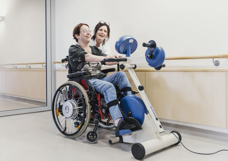 Bewohnerin Katharina übt am Ergometer.