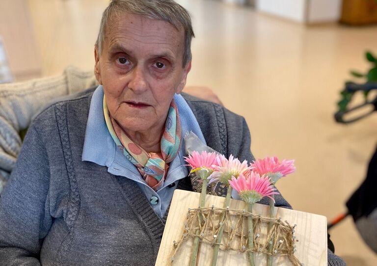 Bewohnerin hält ihr Bild hoch.