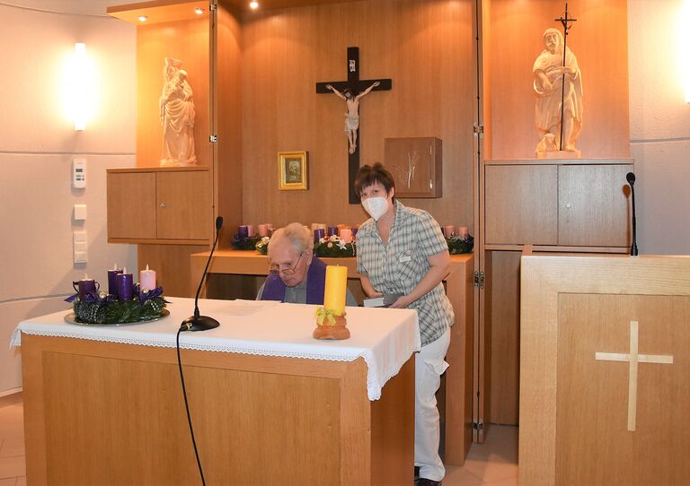 Pfarrer Loley weiht die Adventkränze.