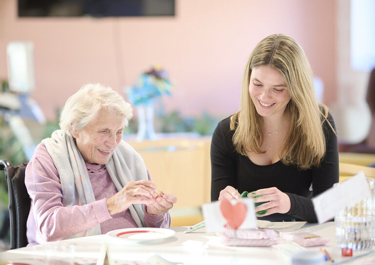 Eine Studentin bastelt Marzipanfiguren gemeinsam mit einer Bewohnerin.  Eine Studentin bastelt Marzipanfiguren gemeinsam mit einer Bewohnerin.