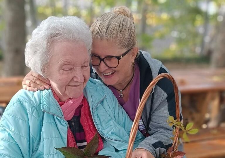 Eine Kollegin und eine Bewohnerin lachen miteinander