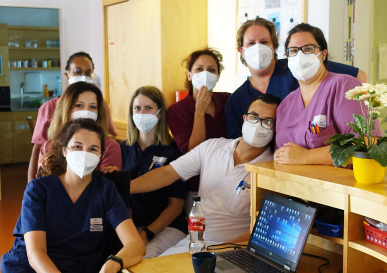 Einige Mitarbeiter*innen stehen am Stützpunkt zusammen und posieren für ein Foto.