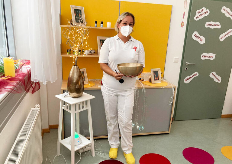 Eine HB Kollegin hält eine Klangschale in den Händen.