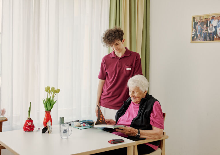 Zivildiener und Margarethe schauen gemeinsam in die Bibel