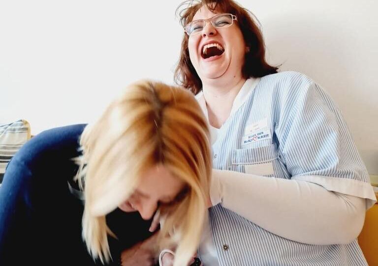 Zwei Kolleginnen lachen miteinander