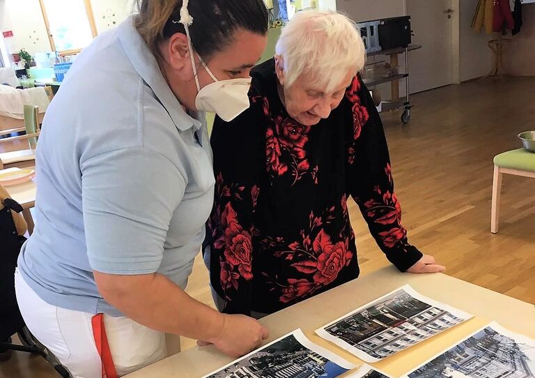Mitarbeiterin Marija bastelt gemeinsam mit Bewohnerin Maria das Plakat.