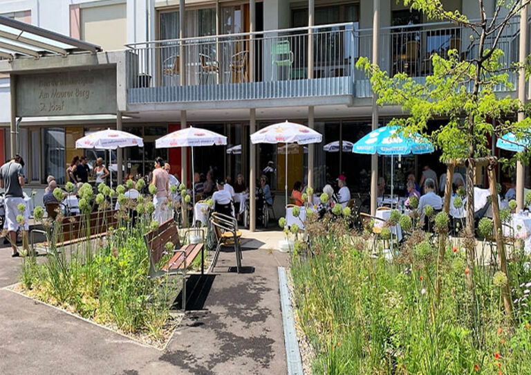 Die Bewohnerinnen und Bewohner genießen gemeinsam mit dem HB Team ein Grillfest vor dem Haus.