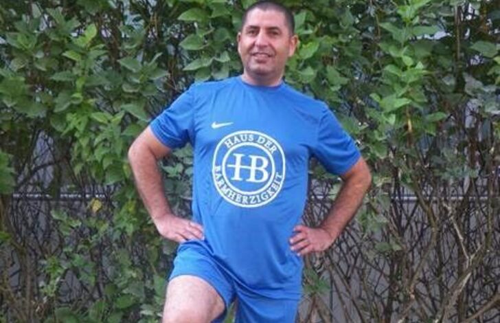 Birkent Zeynel stehend mit den Armen in den Hüften und den Fuß am Fußball