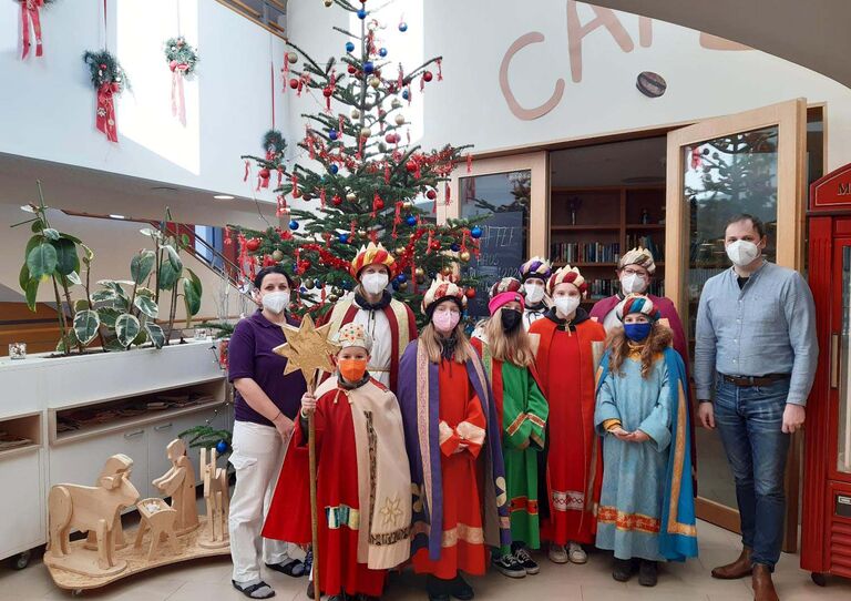 Einige Sternsinger aus der Pfarre Poysdorf stehen für ein Gruppenbild mit der Pflegedienstleiterin Tanja Glander und dem Heimleiter Gregor Kopa zusammen.
