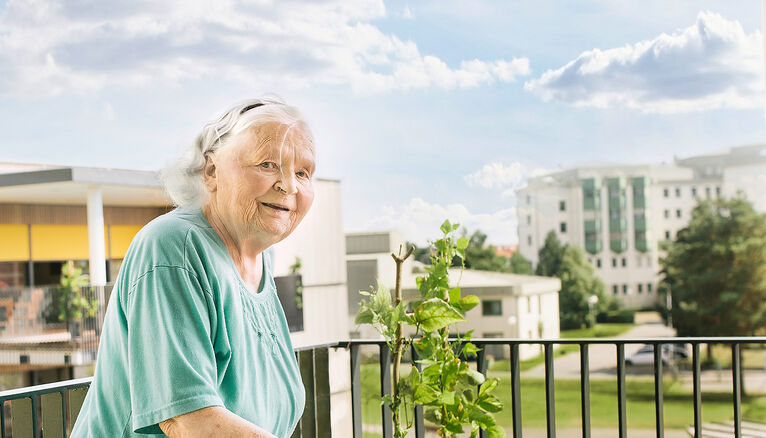 Eine Bewohnerin auf einer Terrasse in einem HB Pflegeheim.