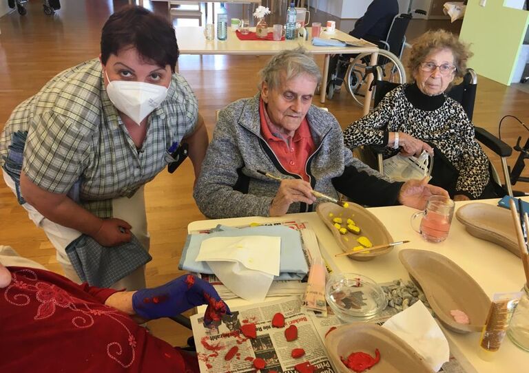 Bewohnerinnen und Mitarbeiter*innen basteln an den Kunstwerken.