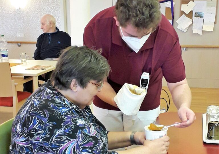Zivildiener Philipp befüllt mit der Hilfe einer Bewohnerin die Krapfen mit Marmelade.
