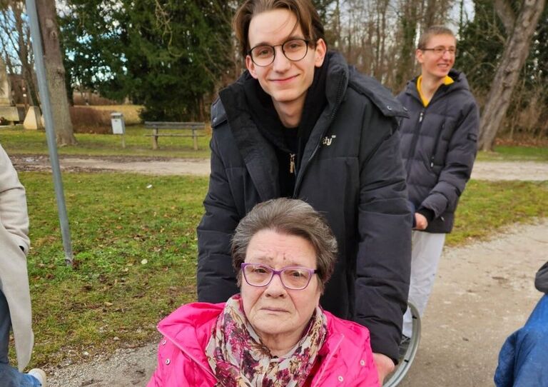 Zivildiener schiebt Bewohnerin im Rollstuhl Zivildiener schiebt Bewohnerin im Rollstuhl