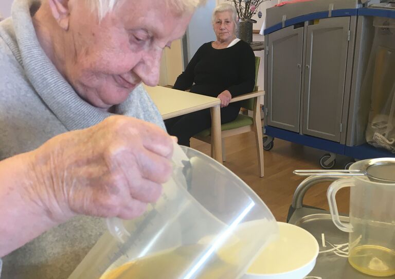 Eine Bewohnerin füllt den Sirup in Flaschen.