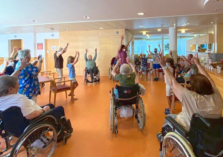 Die Kinder turnen mit Bewohner*innen.