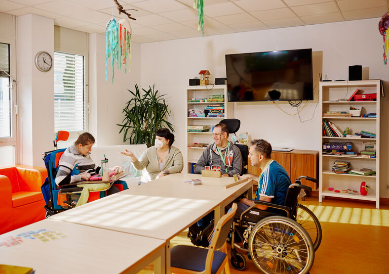 (ZAB), 21. Bezirk: 3 Kunden sitzen mit einer Mitarbeiterin rund um den Tisch. 