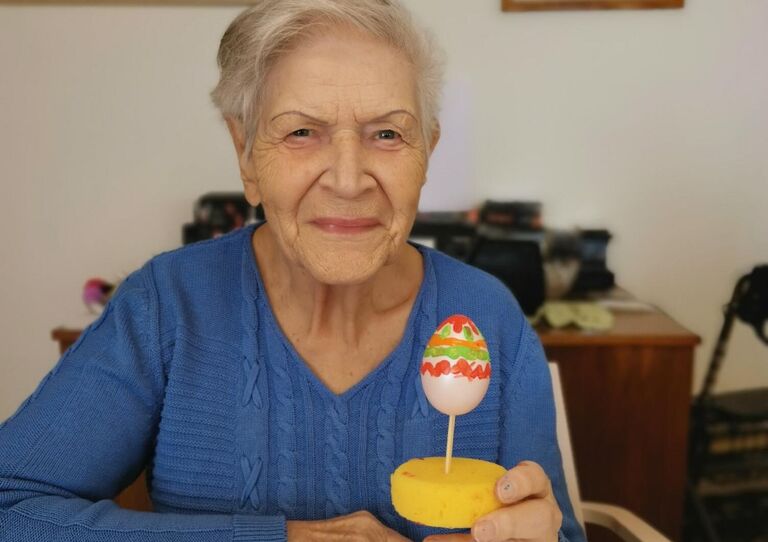 Bewohnerin hält selbst bemaltes Osterei in den Händen.
