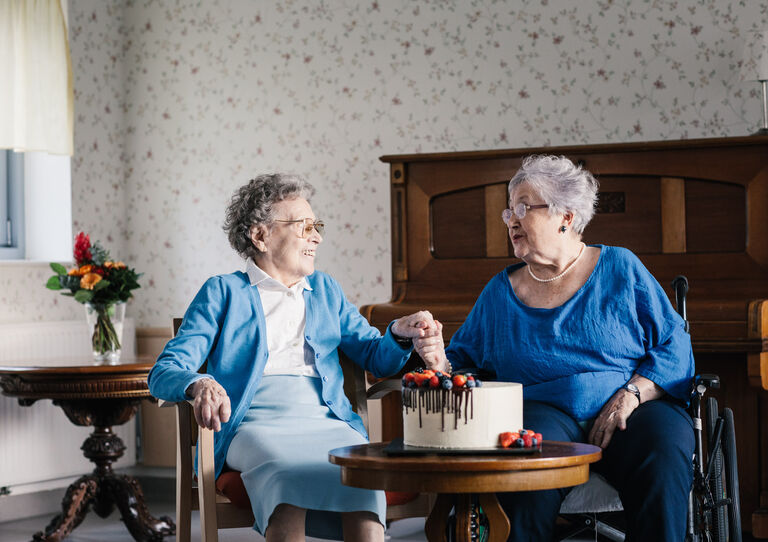 Zwei Bewohnerinnen halten sich an den Händen.