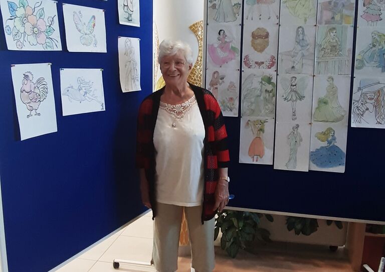 Eine Bewohnerin vor den Kunstwerken.