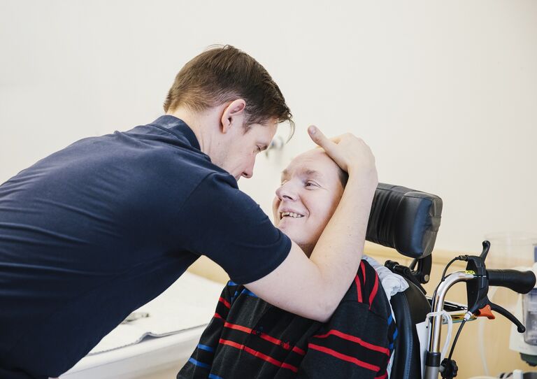 Therapeut Daniel macht mit Paul Übungen, um seine Kopfhaltung zu entspannen.