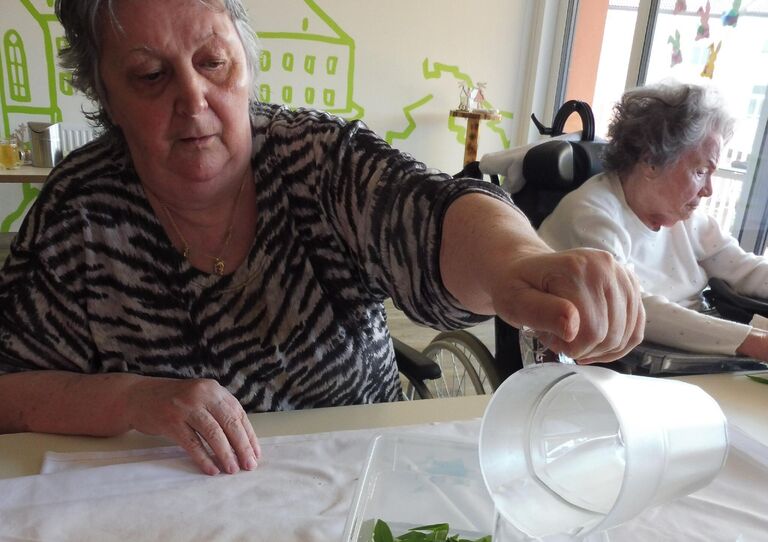 Eine Bewohnerin schüttet Wasser auf den Bärlauch.