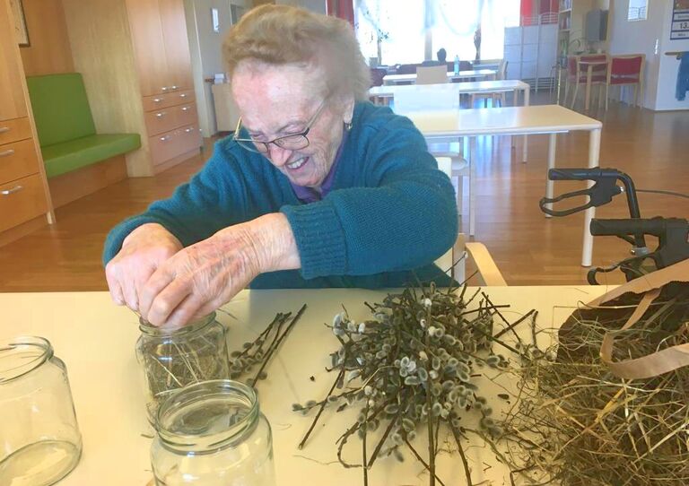 Eine Bewohnerin bastelt Osternester.
