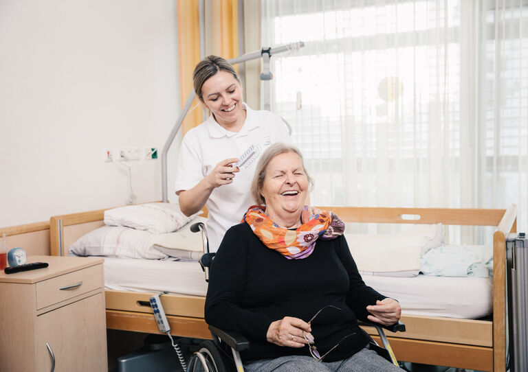Eine Mitarbeiterin kämmt eine Bewohnerin