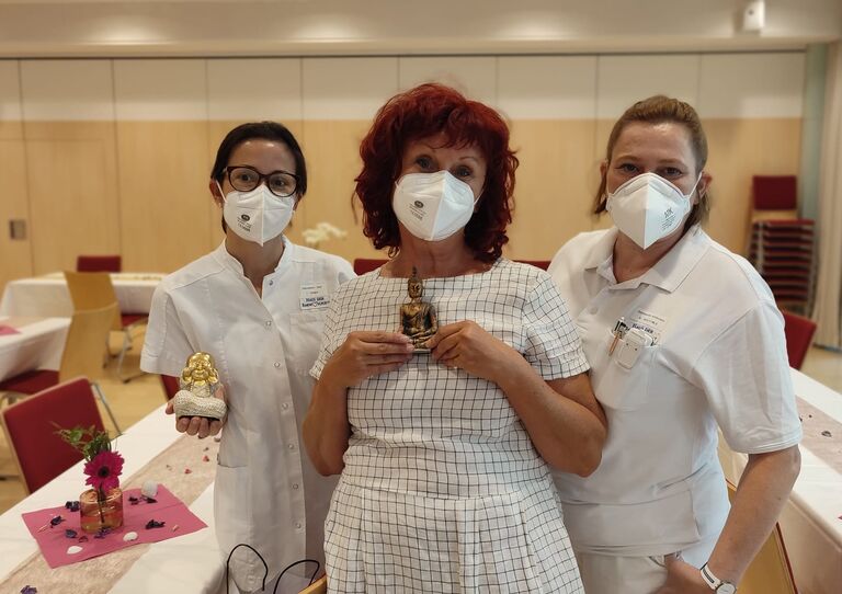 Kolleginnen stehen zu dritt zusammen und posieren für ein Foto.