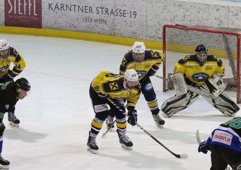 Vladimir Oleksak mit anderen Eishockeyspielern auf der Eisfläche während eines Spiels. Er steht im Tor.