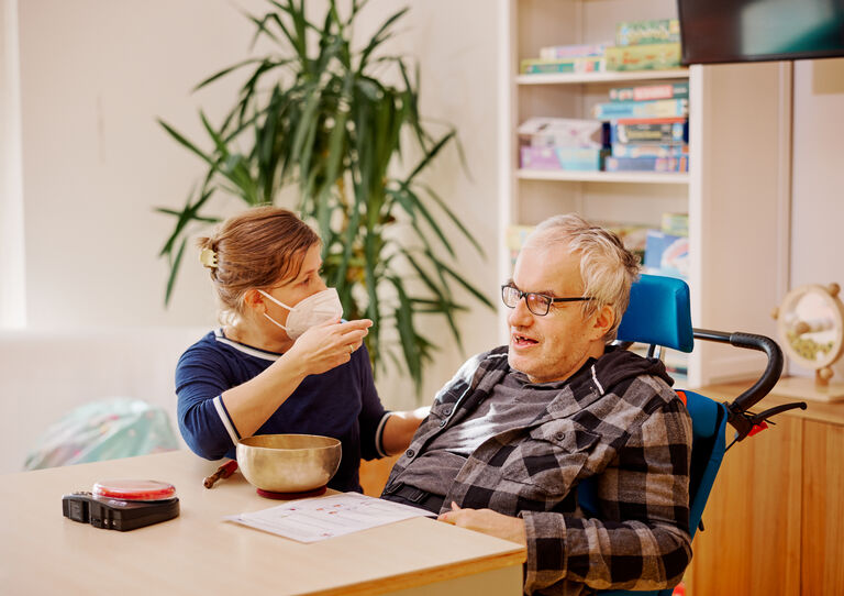 BTZ Maria-Rekker-Gasse: Eine Mitarbeiterin füttert einen Kunden.