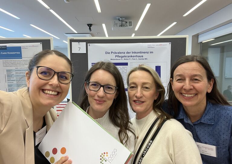 Einige Kolleginnen stehen mit einer Urkunde in den Händen zusammen.