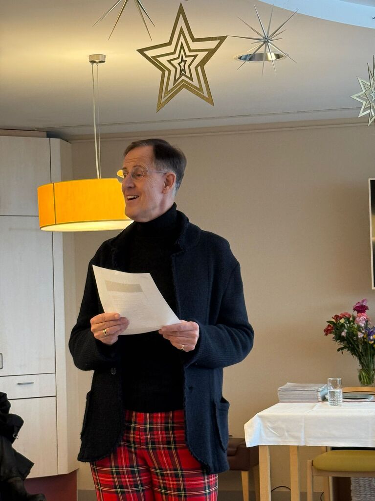 Rene Rumpold mit Liedtext in der Hand singt für Bewohner*innen im Haus der Barmherzigkeit