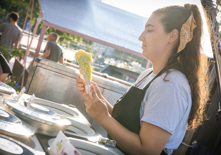 Eine Eisverkäuferin richtet gerade eine Tüte mit zwei Kugeln Leones Eis her.