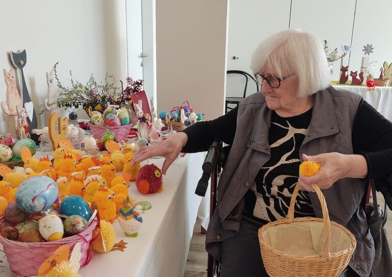 Bewohnerin sortiert Deko-Artikel für den Ostermarkt.