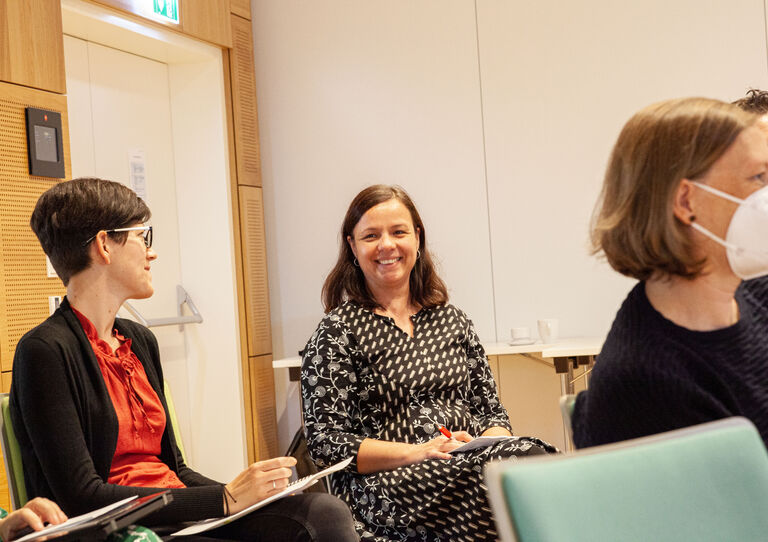 Teilnehmerin lächelt in die Kamera, zu sehen sind auch zwei weitere Teilnehmerinnen daneben und davor