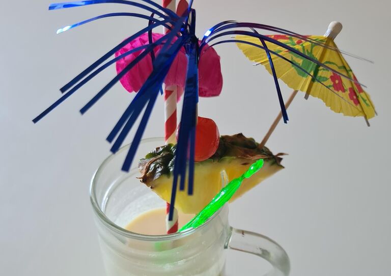 Ein Cocktail Glas mit Schirmchen und Strohhalm