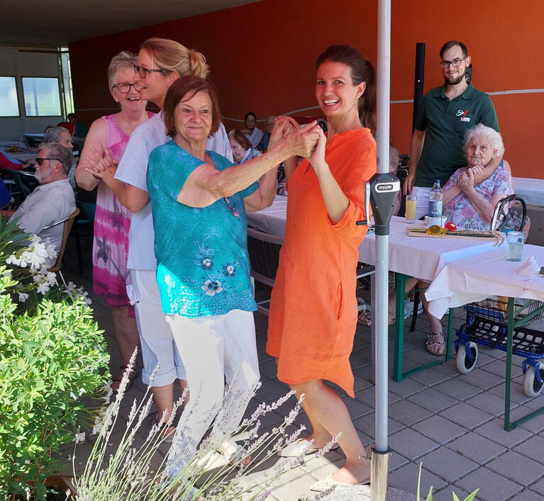 Veronika Schauer tanzt mit einer Bewohnerin beim Sommerfest
