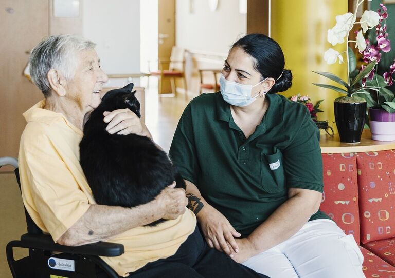 Bewohnerin mit Mitarbeiterin und Katze.