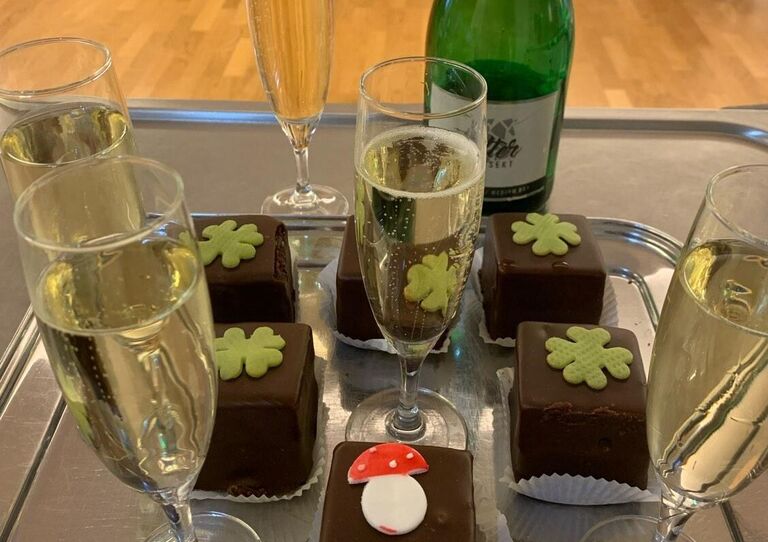 Einige Sektgläser und Sacherwürfel mit Glücksbringer sind zu sehen.