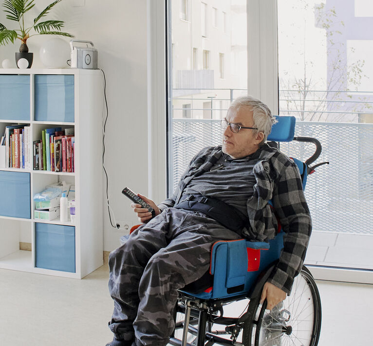 HABIT Kunde in seinem Rollstuhl - Großaufnahme von seinem Zimmer.