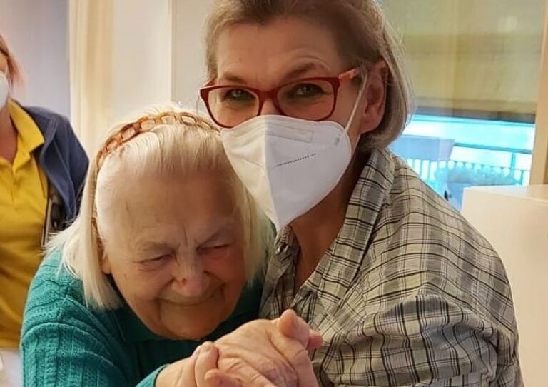 Mitarbeiterin Petra tanzt mit einer Bewohnerin.