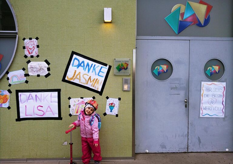 Kind steht vor der mit liebevoll gezeichneten Bildern vor der Fassade. 