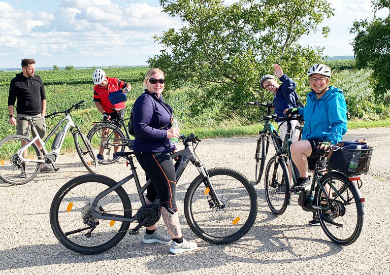Einige Mitarbeiter*innen stehen mit ihren Fahrrädern für einen Schnappschuss zusammen.