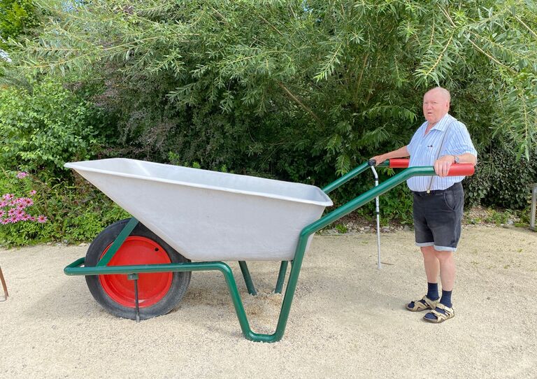 Bewohner mit übergroßer Scheibtruhe